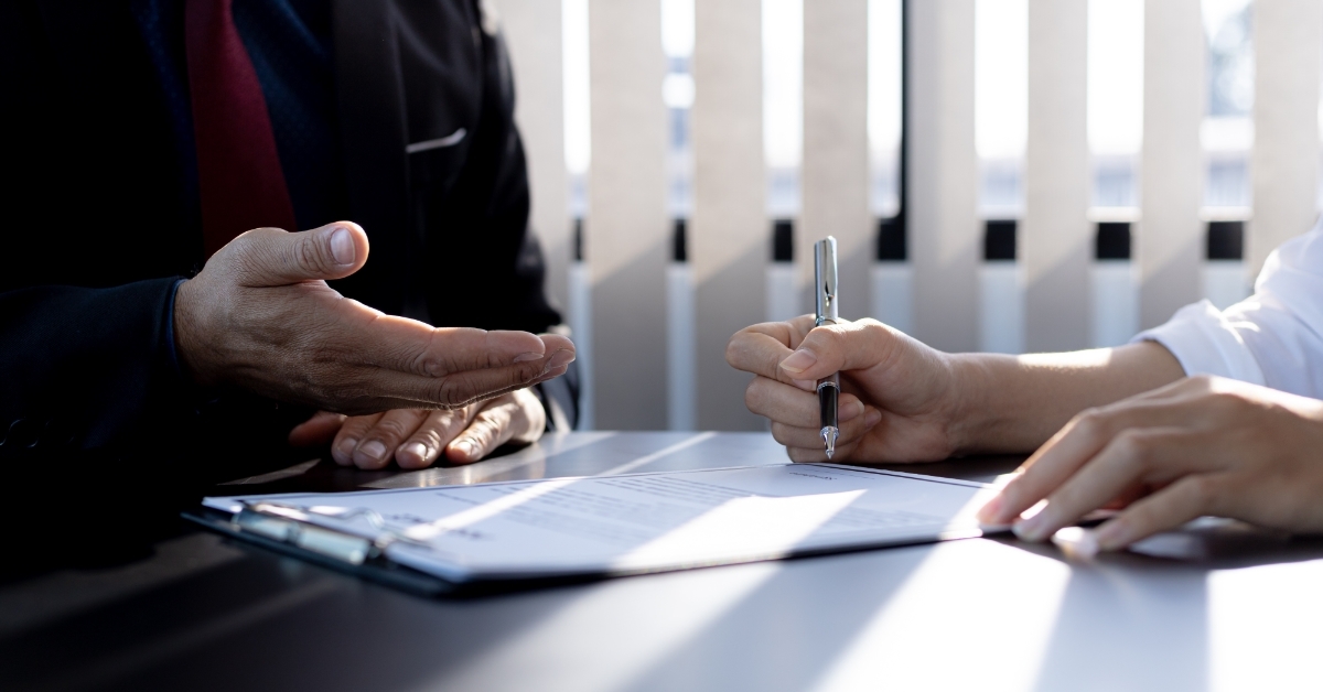 man signing agreement with home insurance agent