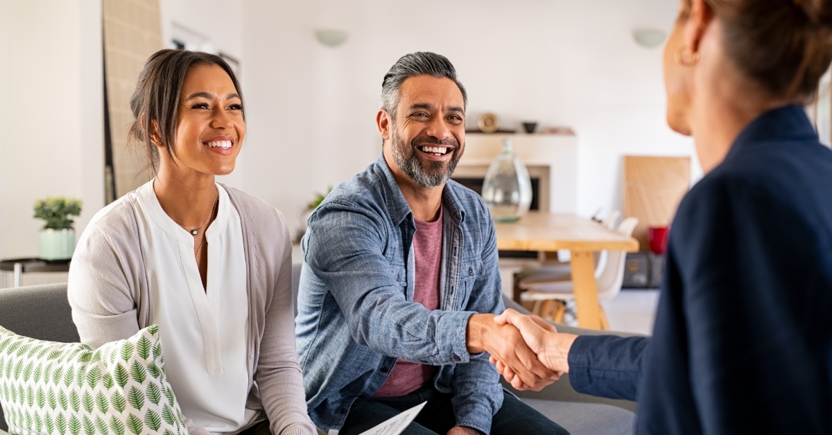 Multiethnic couple handshake with real estate agent