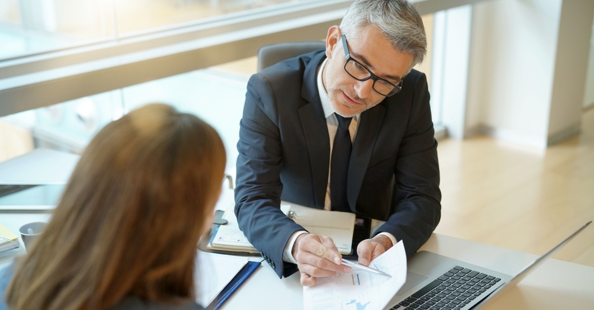 woman signing loan agreement with banker