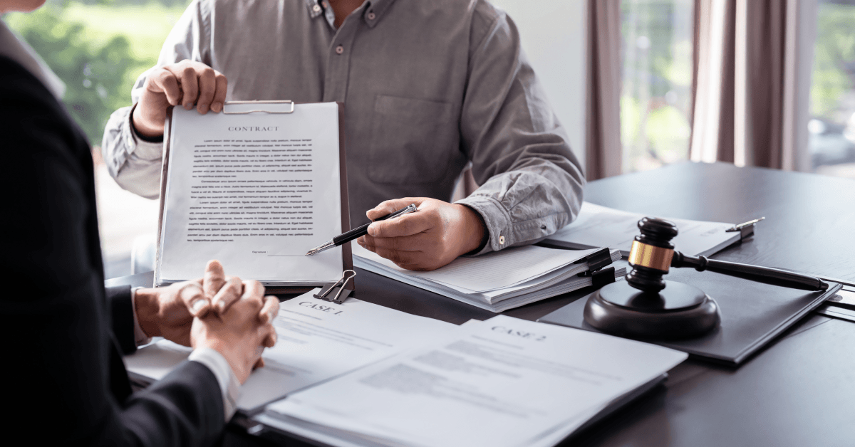 lawyer showing contract and pointing the signature box