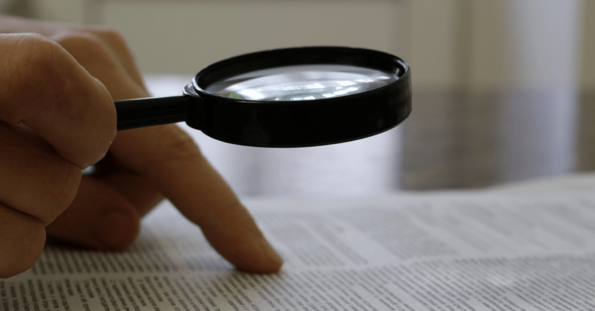 person reads the document through a magnifying glass