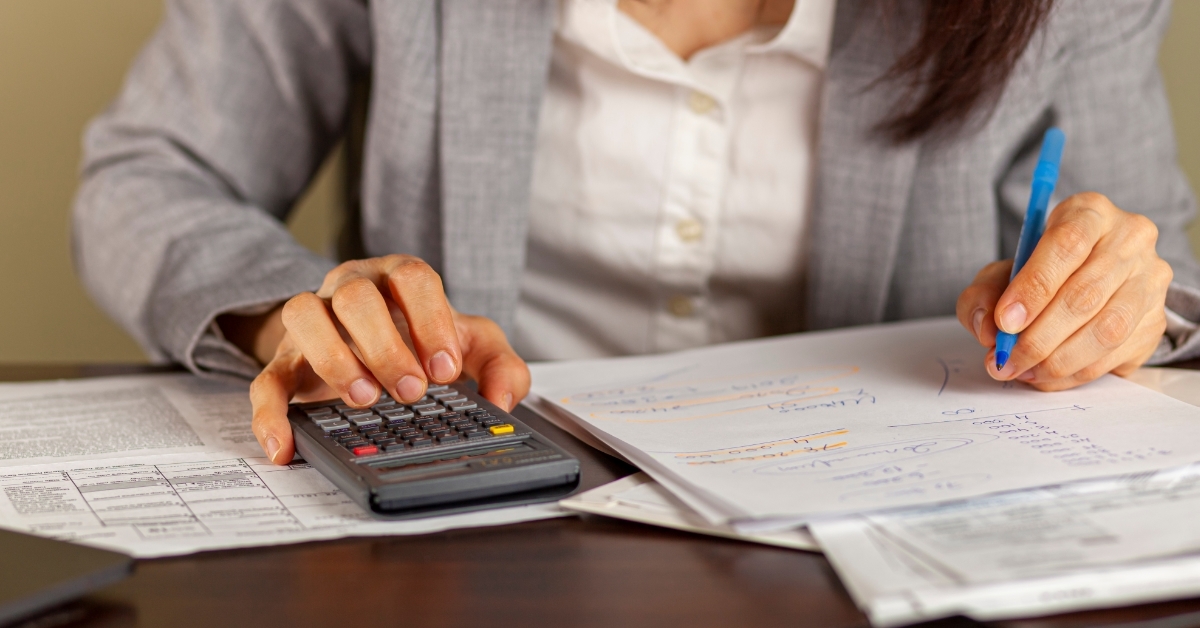 business woman calculating taxes at work