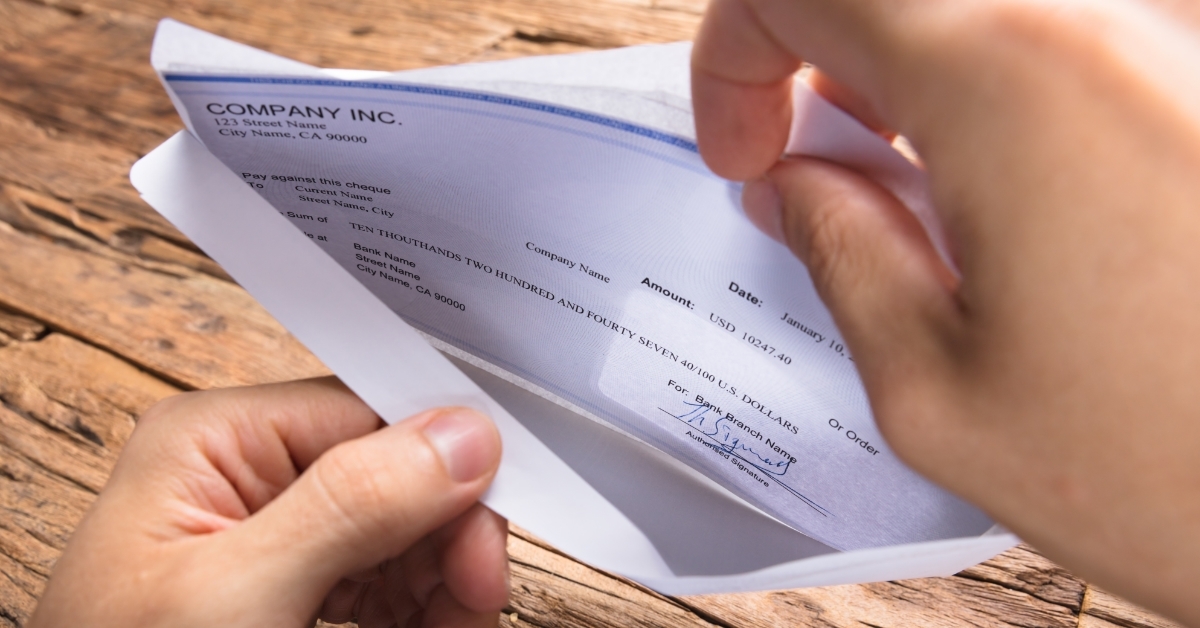 Businessman Opening Envelope With Paycheck