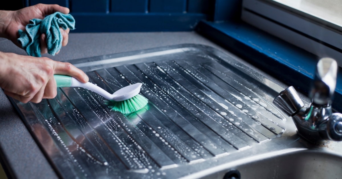 man Cleaning kichen sink with brush