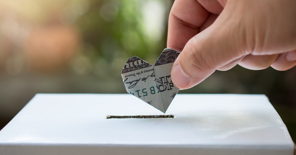 Hand inserting money in box concept donation