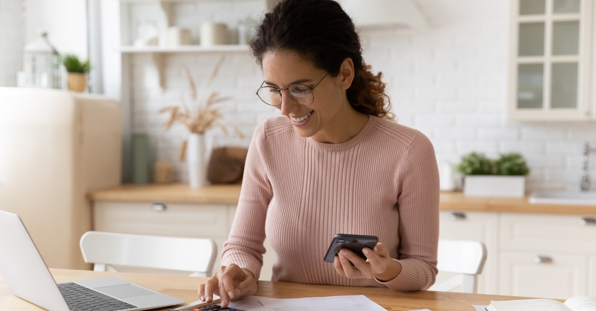 Happy woman calculating bills 