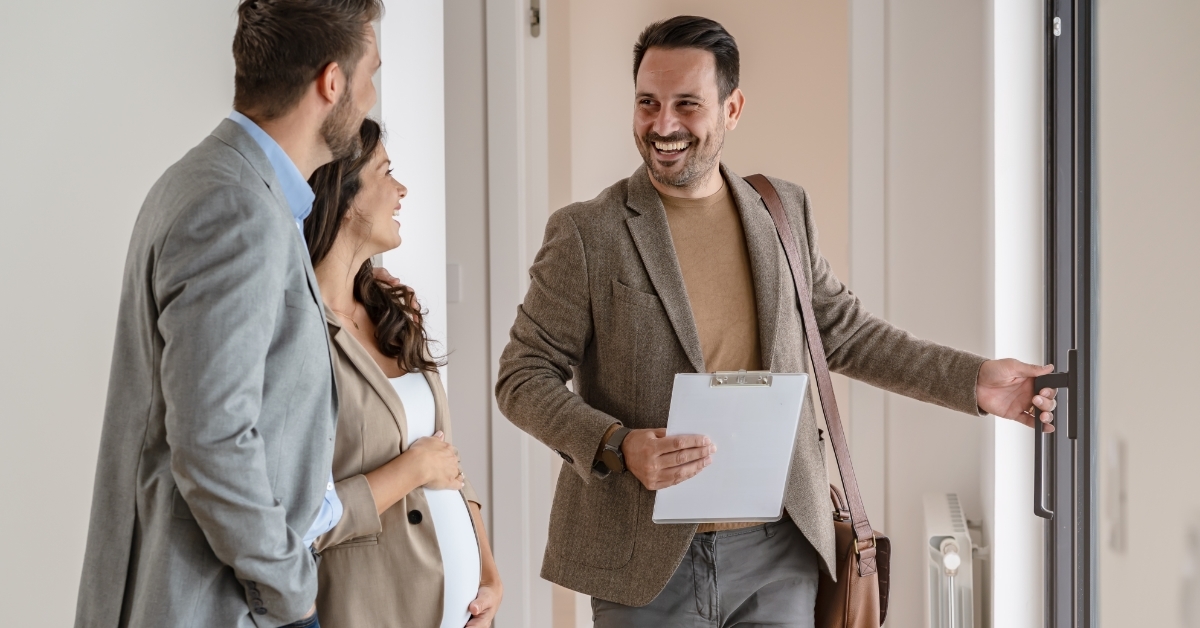 couple with realtor visiting new apartment
