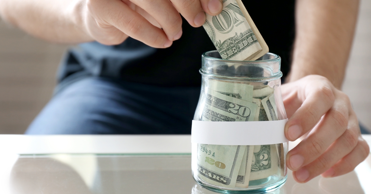 putting money in glass jar