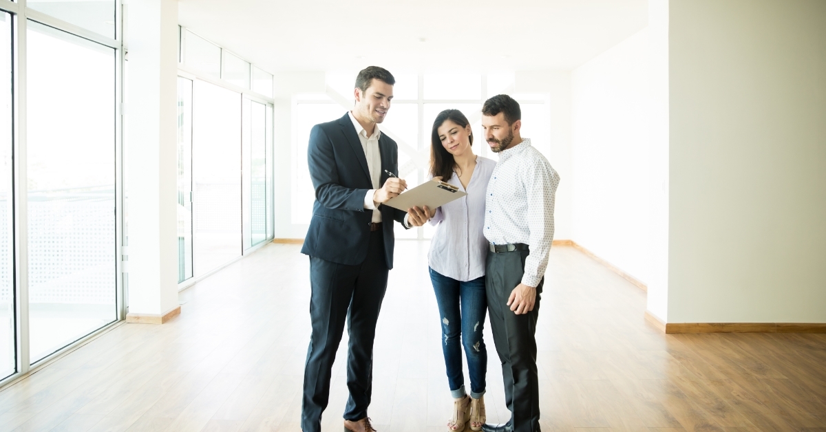 Realtor Explaining Agreement To Couple In Apartment
