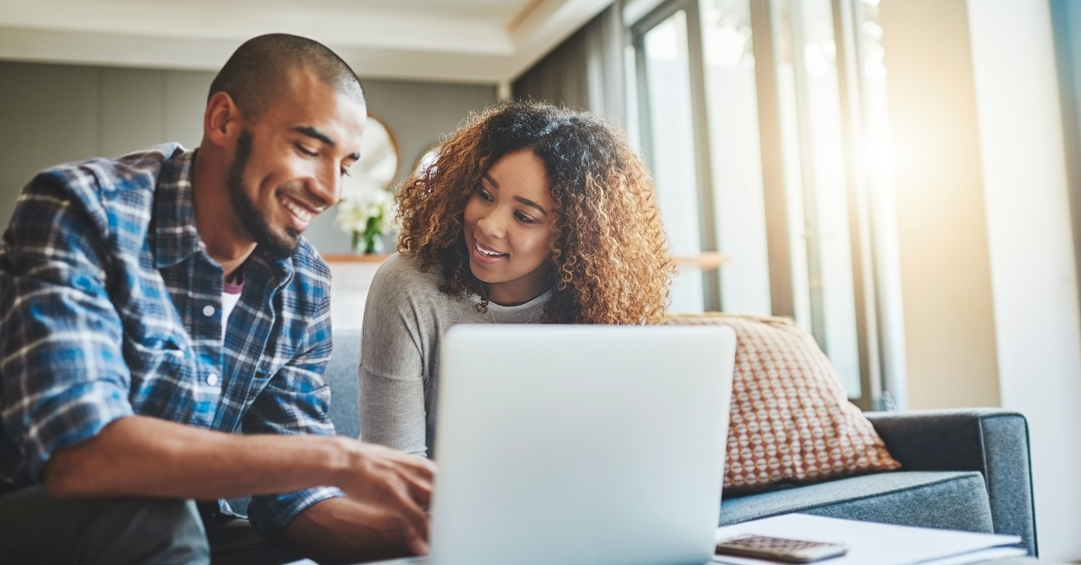 couple booking vacation using laptop