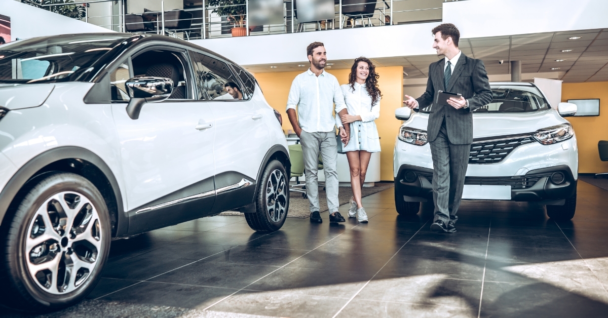 couple choosing new car with sales manager 