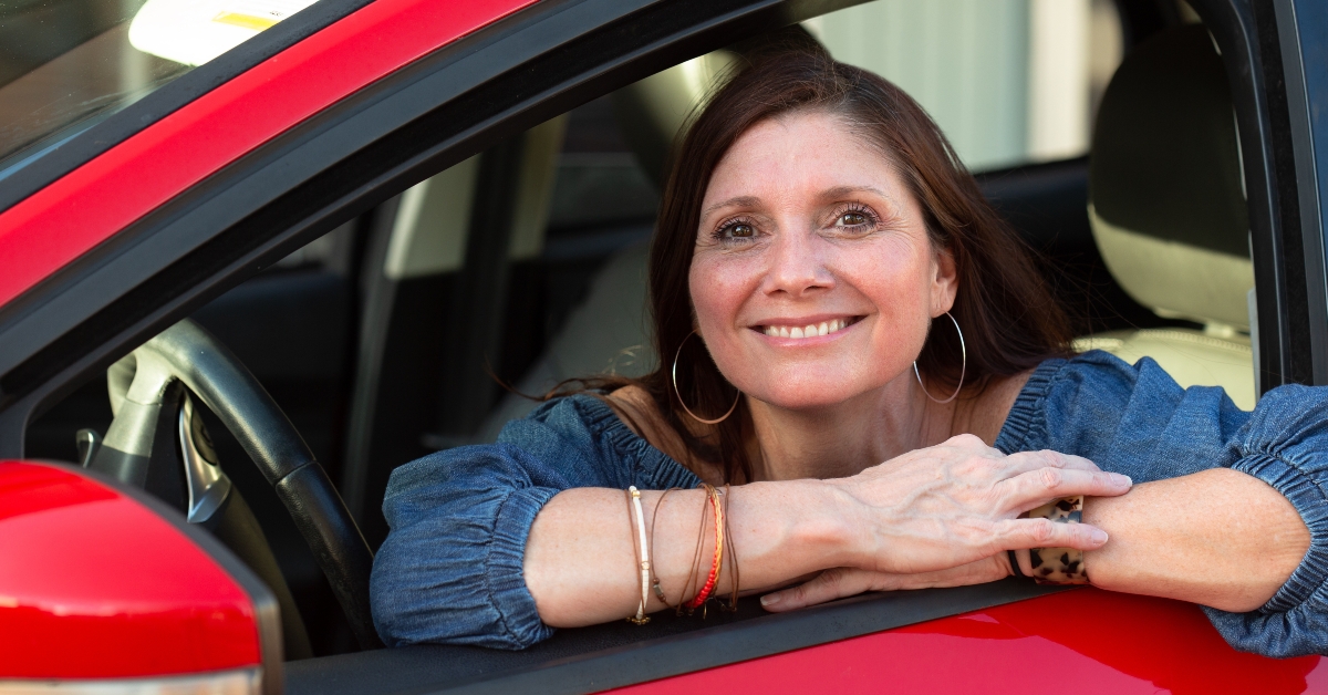 smiling in her red car
