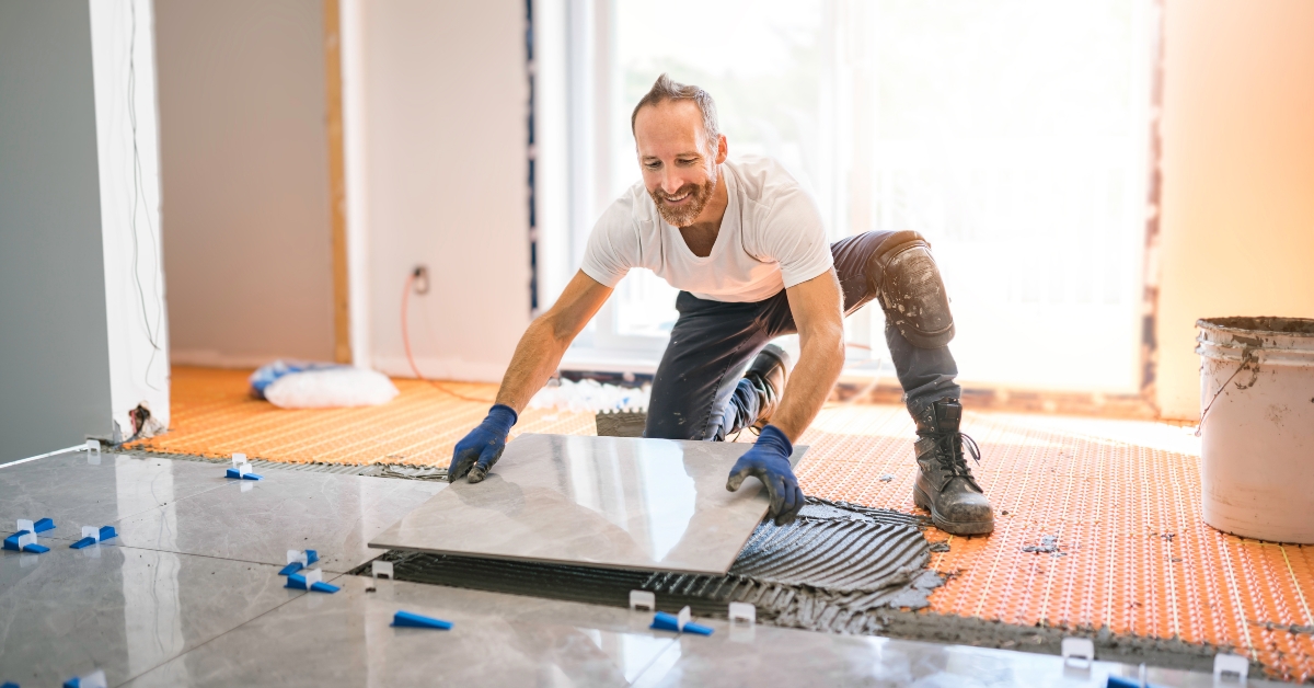 Handyman installing tile on floor