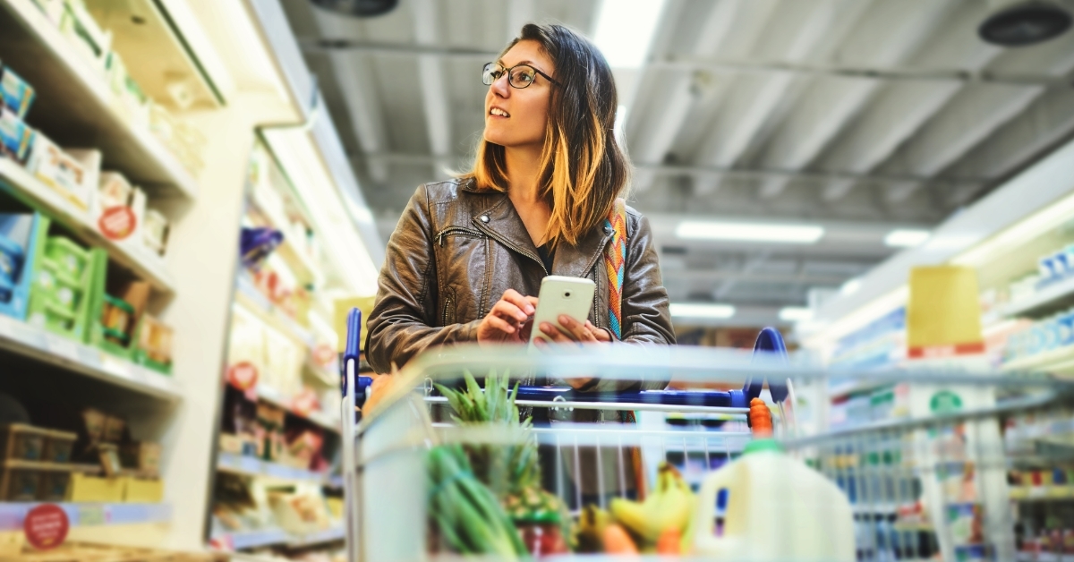 woman using smartphone at grocery store
