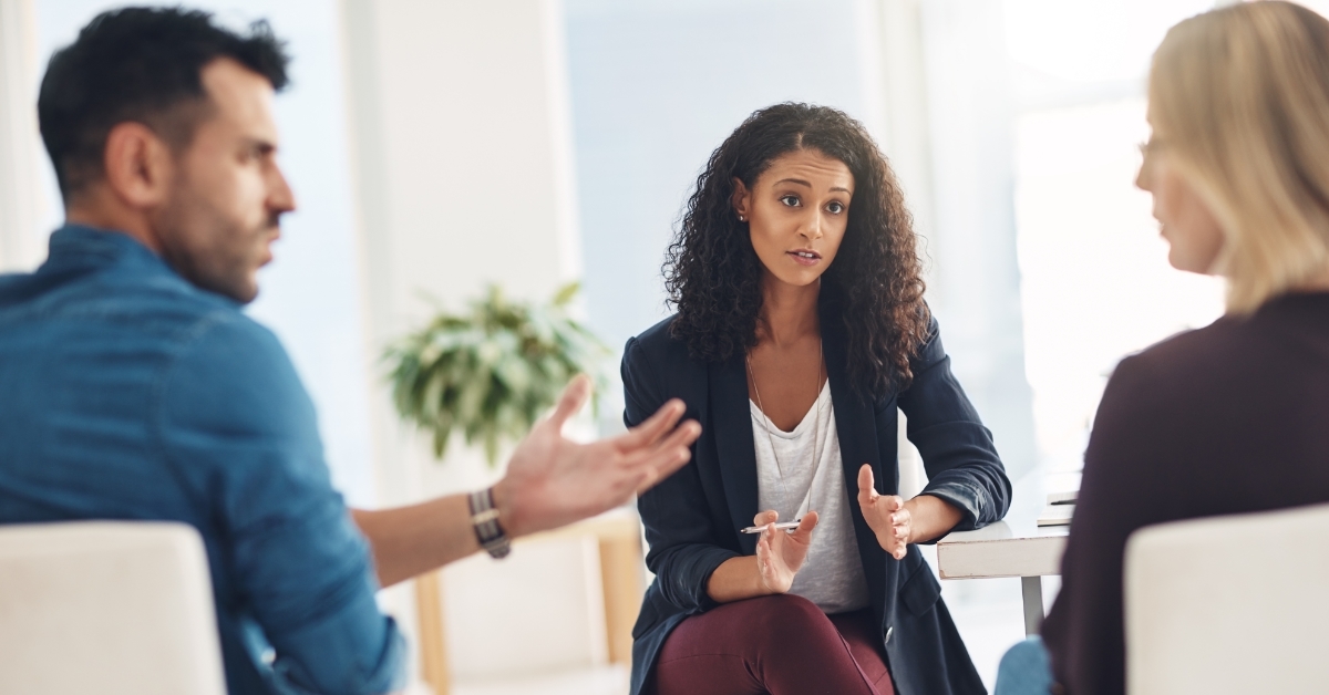 Couple arguing in therapy session with therapist