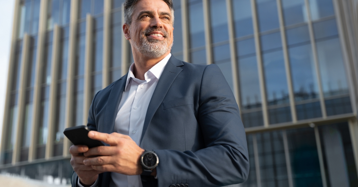 man in suit using smartphone