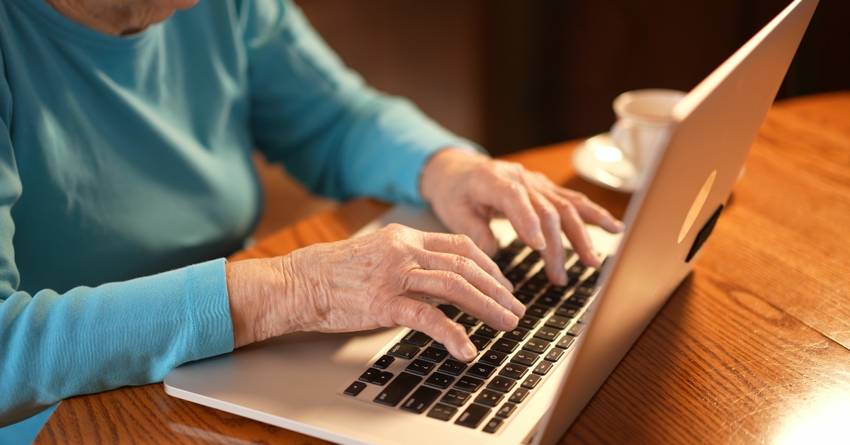 elderly woman typing on laptop