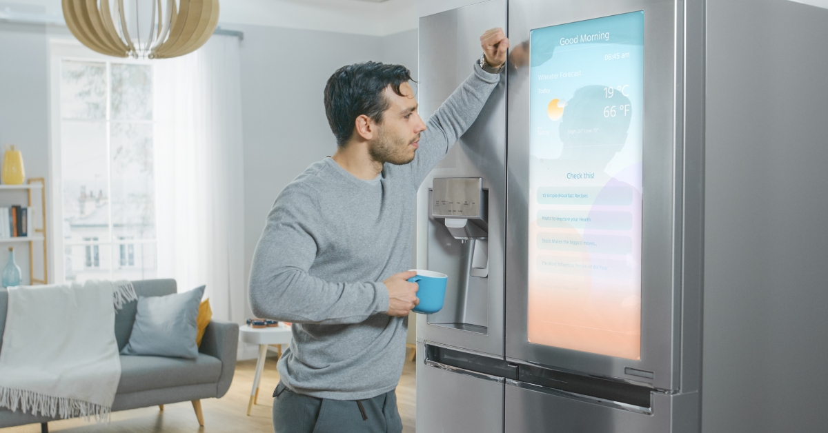 man is standing next to a refrigerator