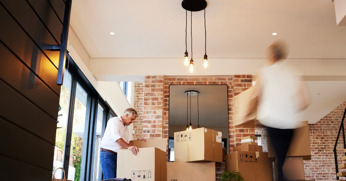 couple checking moving boxes at new home