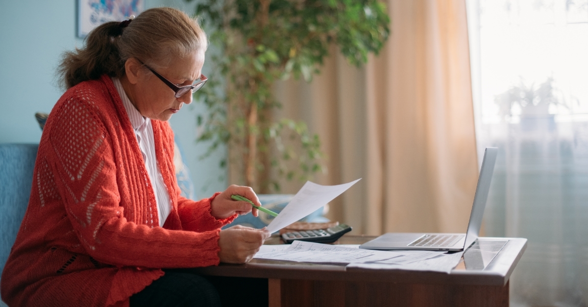 senior woman working from home reading bills