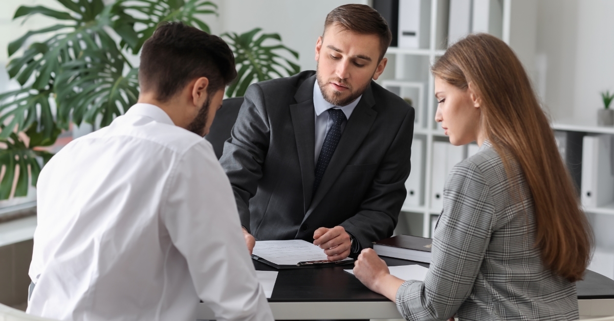 Unhappy couple consulting divorce lawyer in office