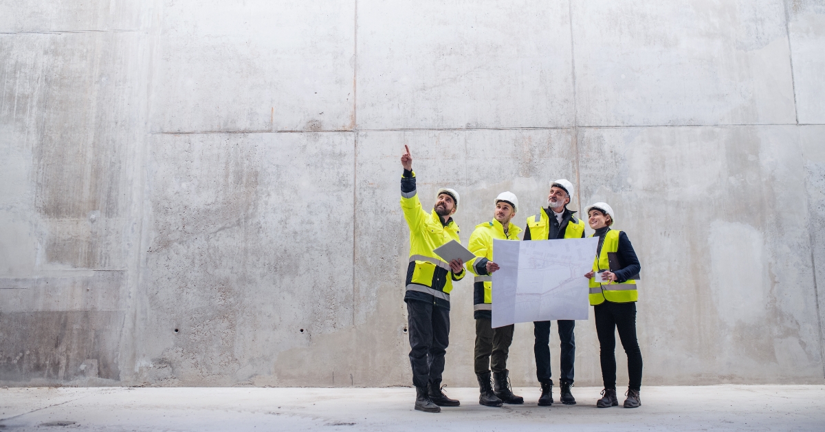  engineers standing against concrete wall