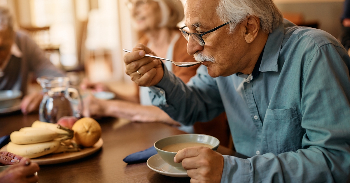 senior man eats soup