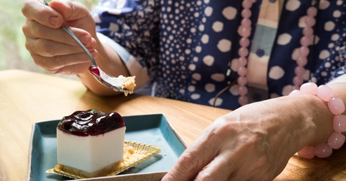 Senoir eating blueberry cheese cake