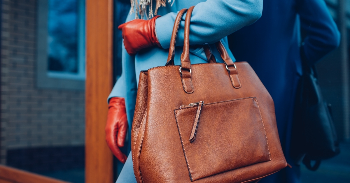 decent lady wearing gloves holding leather purse