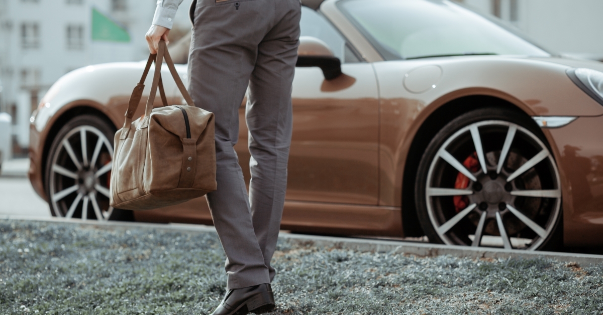 stylish man walking towards sports car