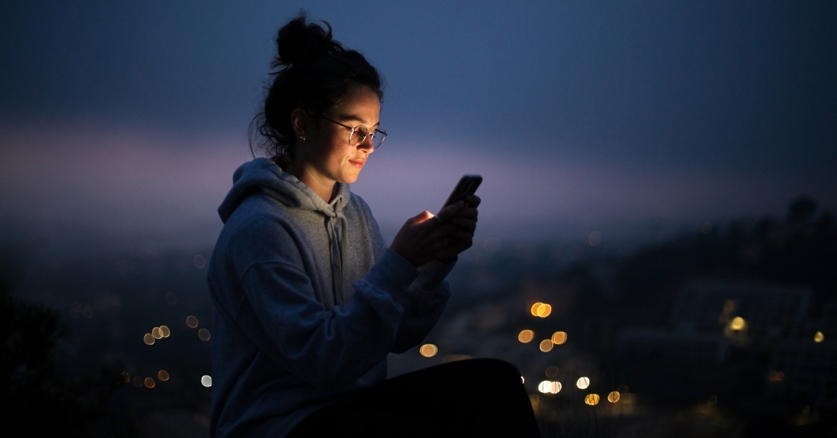 woman uses smartphone at night