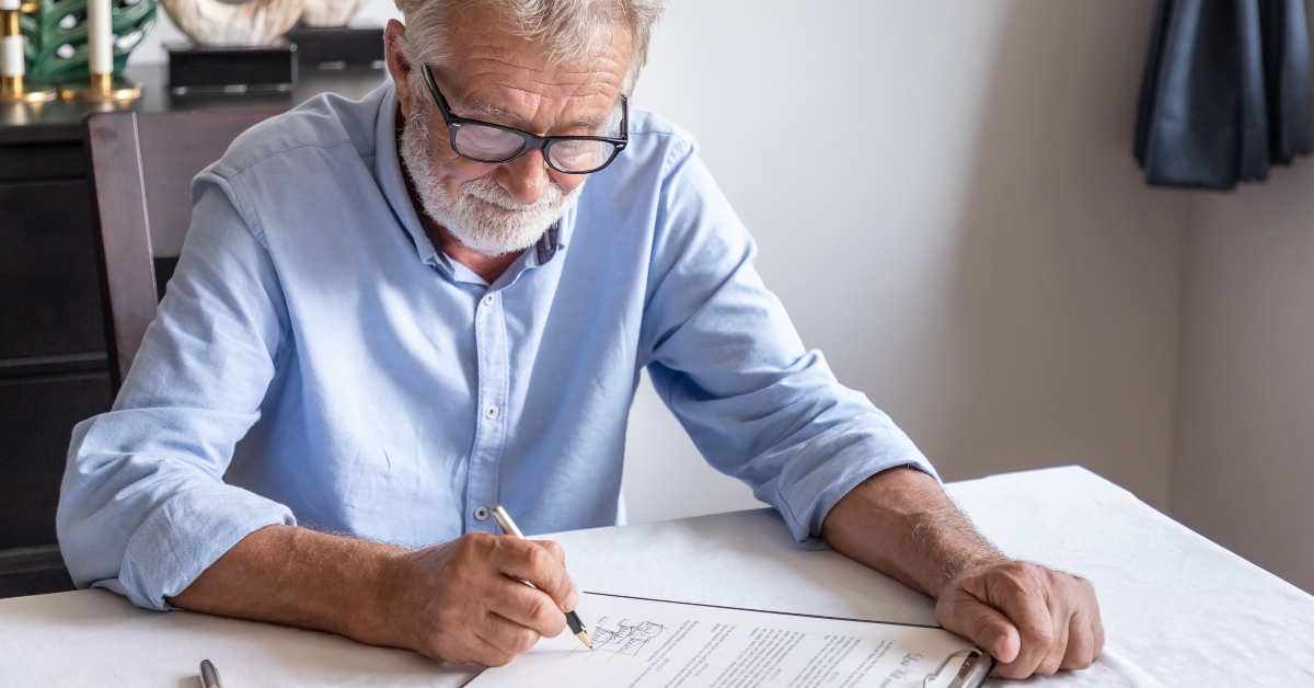 Man examining and signing testament