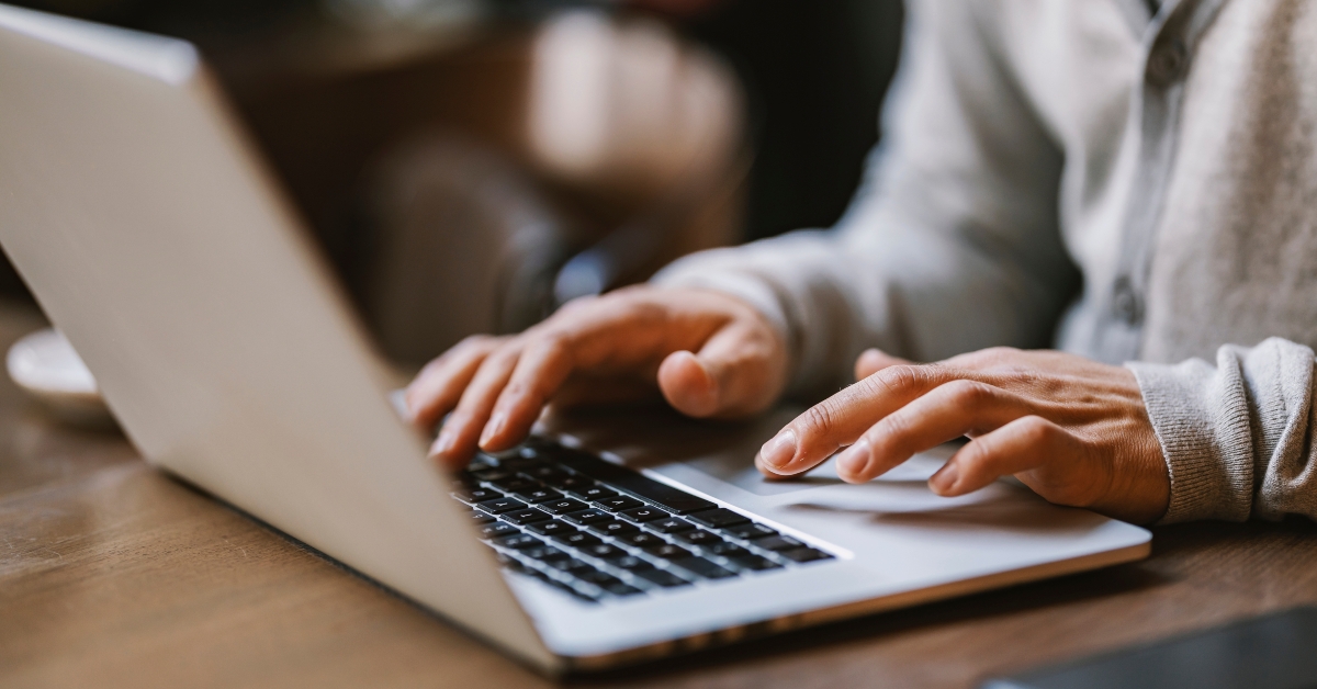  hands typing on a laptop