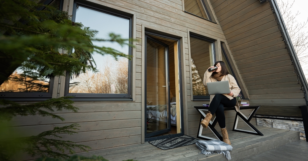 woman working from home outside cabin house
