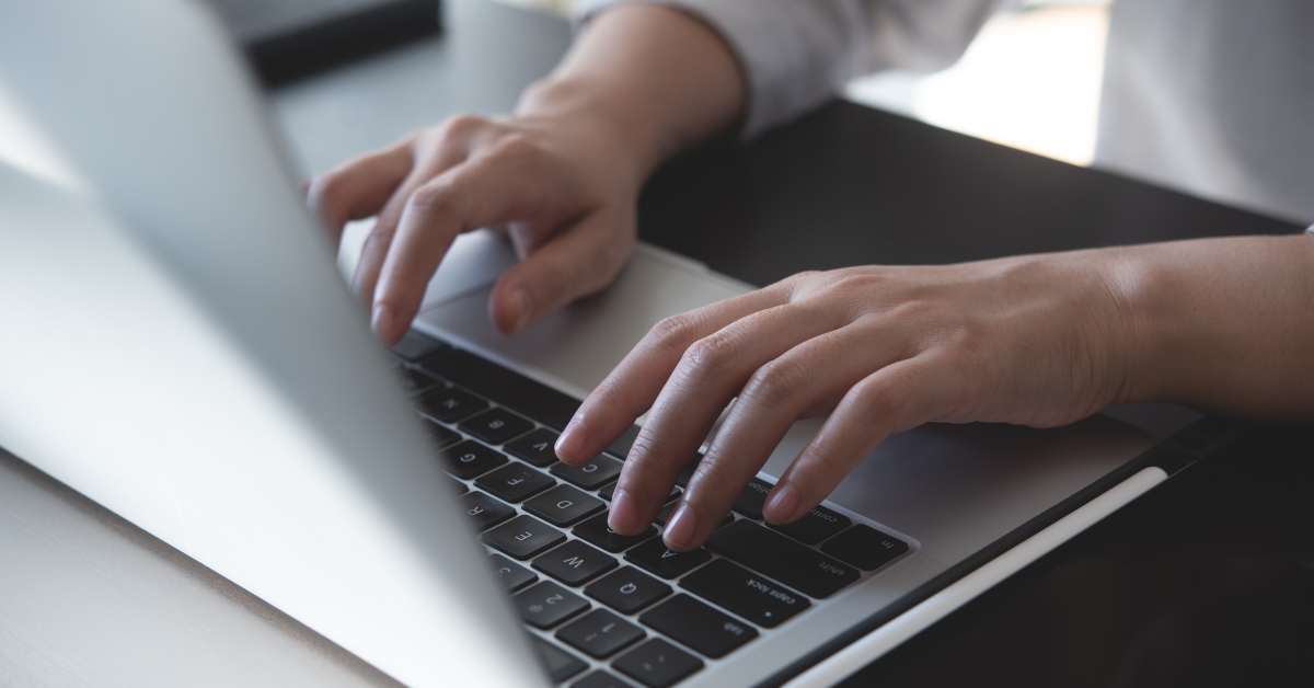 woman hands typing on laptop
