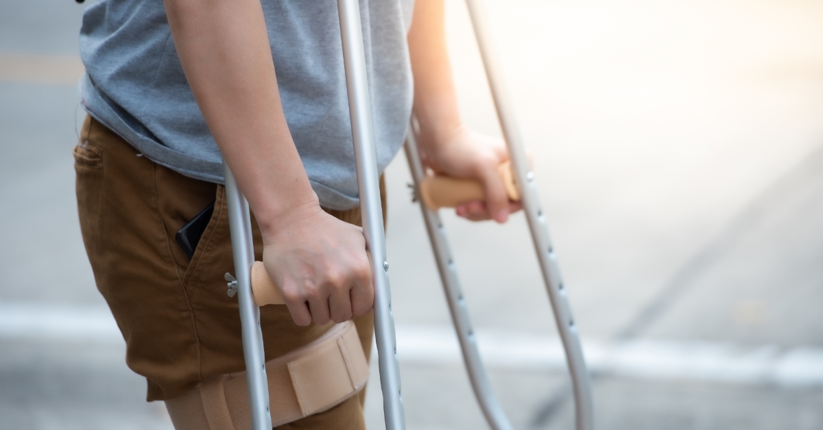 Disabled woman with crutches walking outdoors