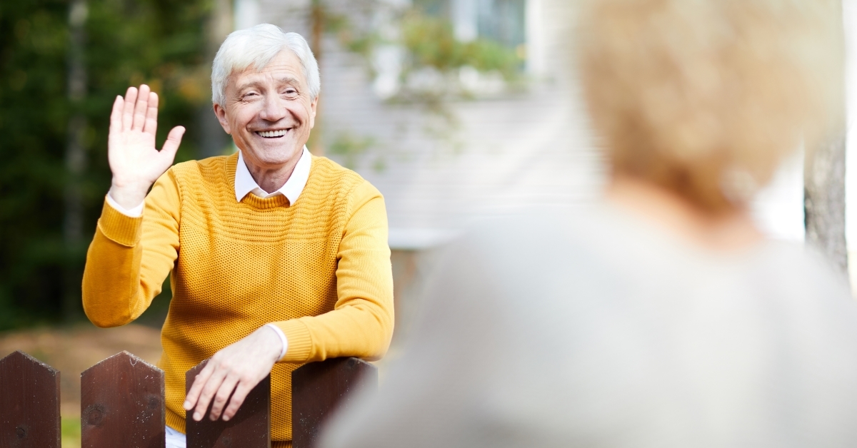 senior man waving hand to neighbor