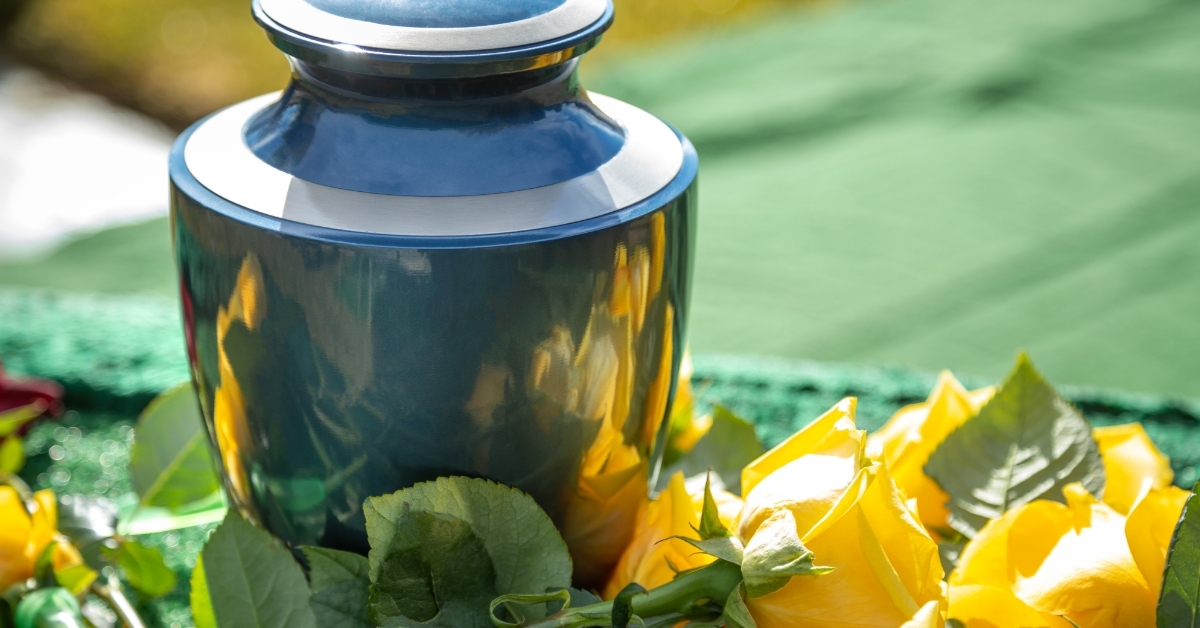 Urn with yellow roses at outdoor funeral