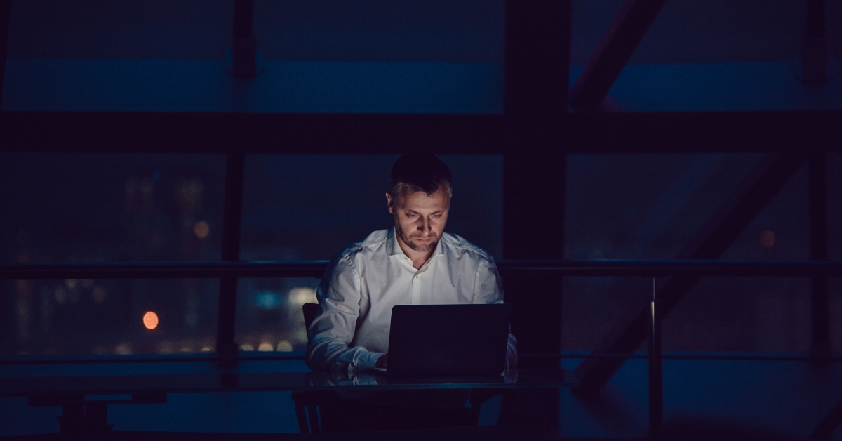 Businessman using laptop at night in office