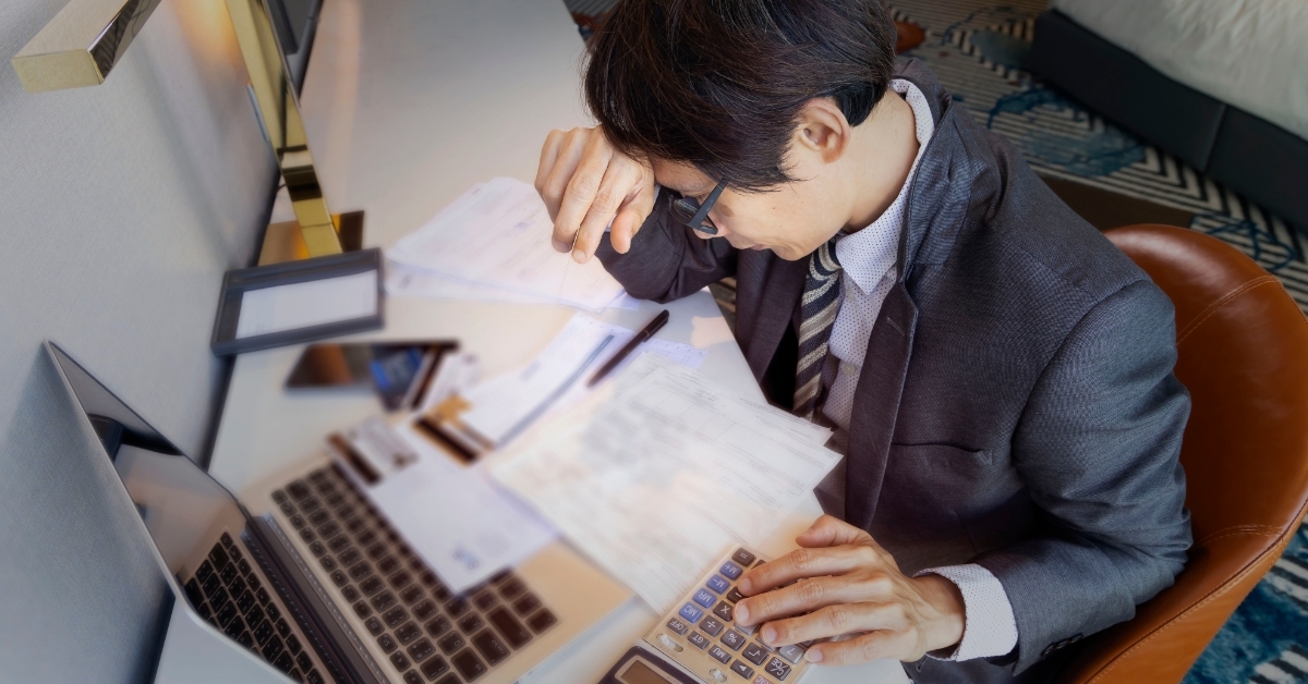 frustrated businessman calculating credit card bills