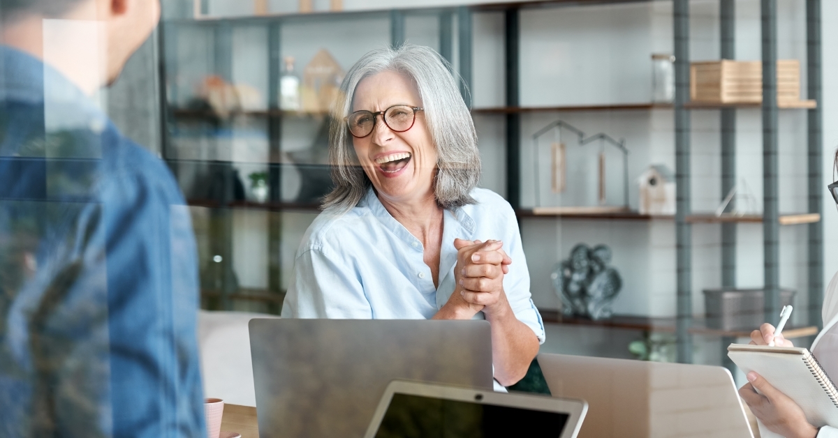 senior business woman laughing with colleagues