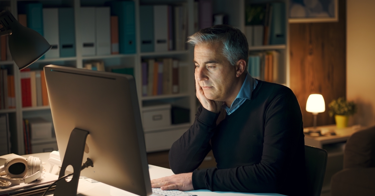 senior man working from home late night