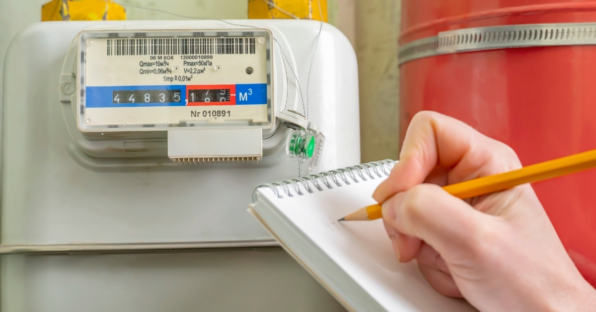 person writing gas meter readings on notebook