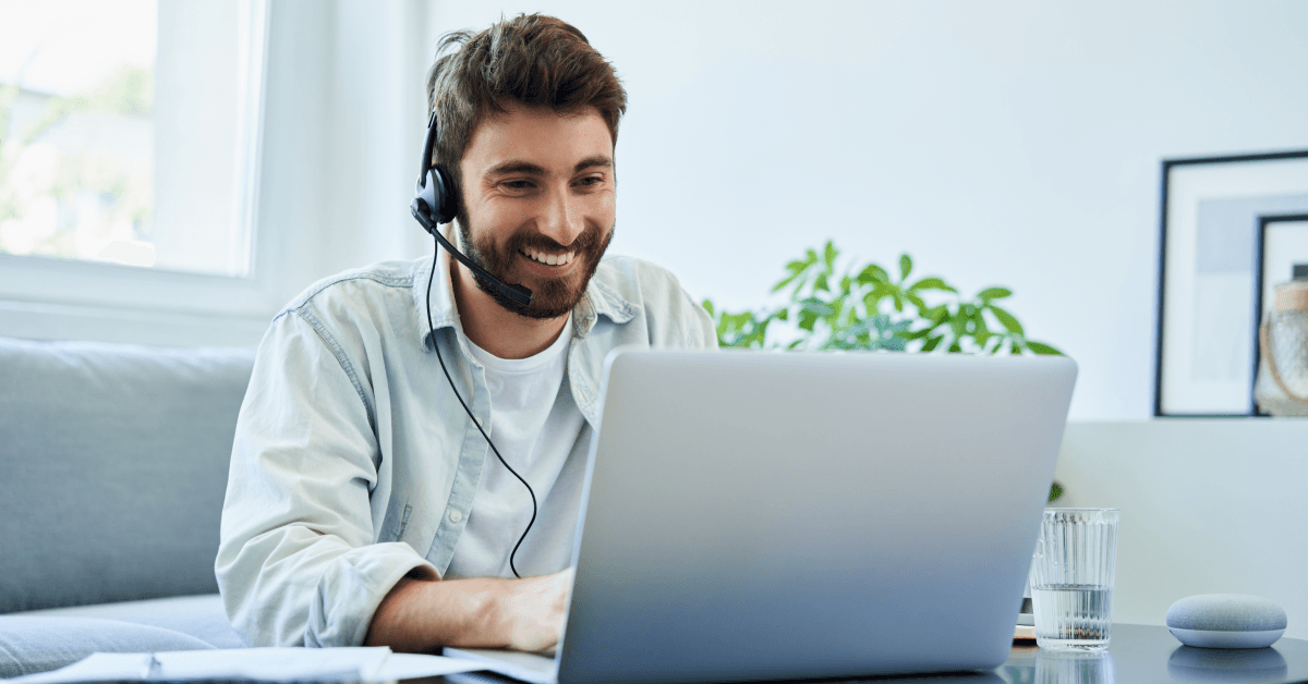 A man wears a headset while using his laptop.