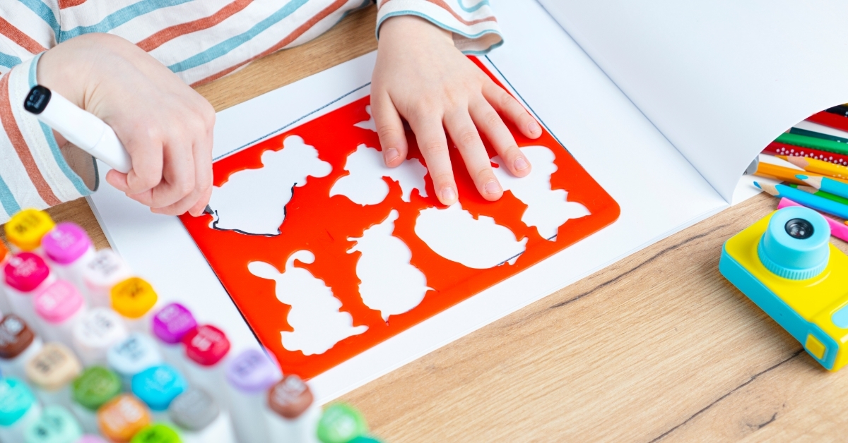 child drawing animals through stencil