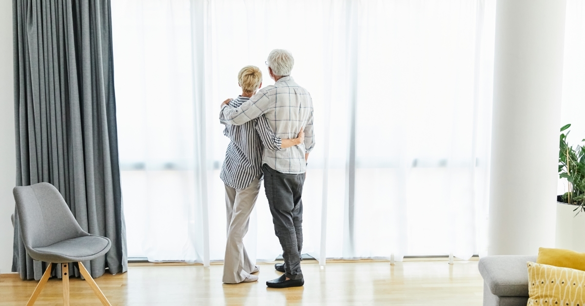 Retired Senior couple hugging in apartment 