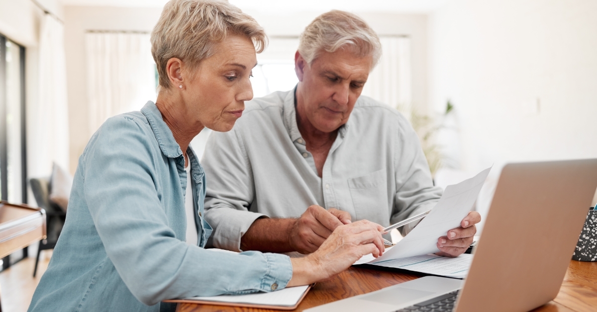 Senior couple planning budget using laptop