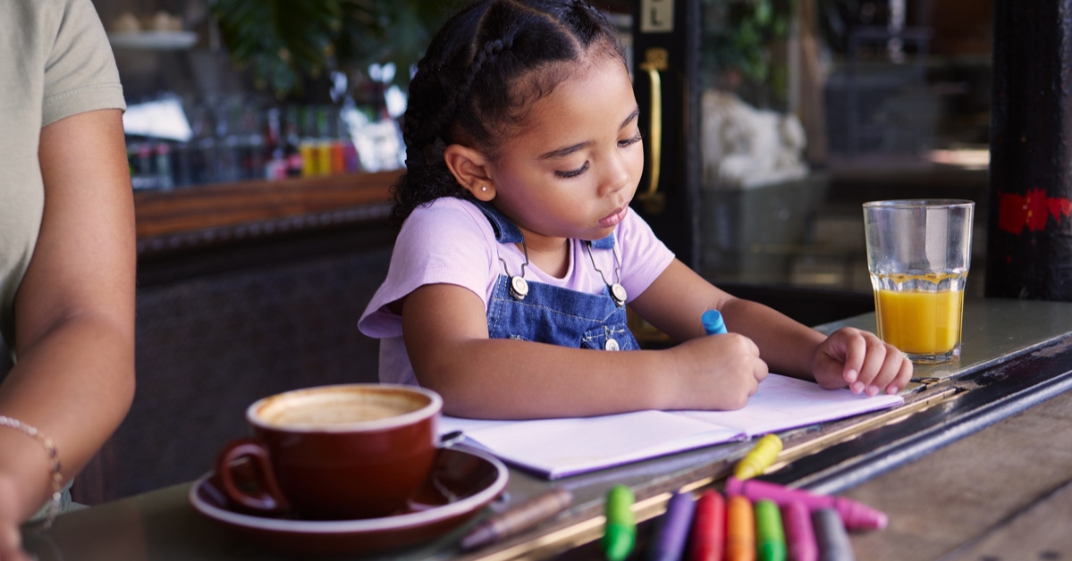 kid coloring at restaurant table