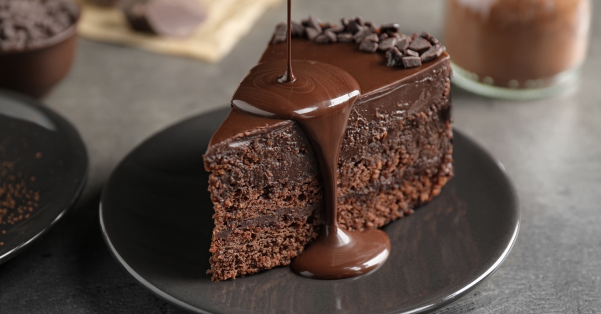 Pouring chocolate sauce on delicious fresh cake 