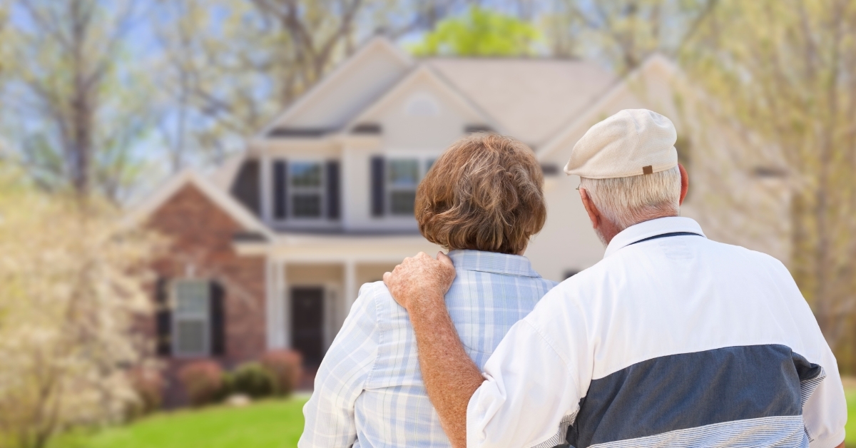 retired senior couple looking at house 